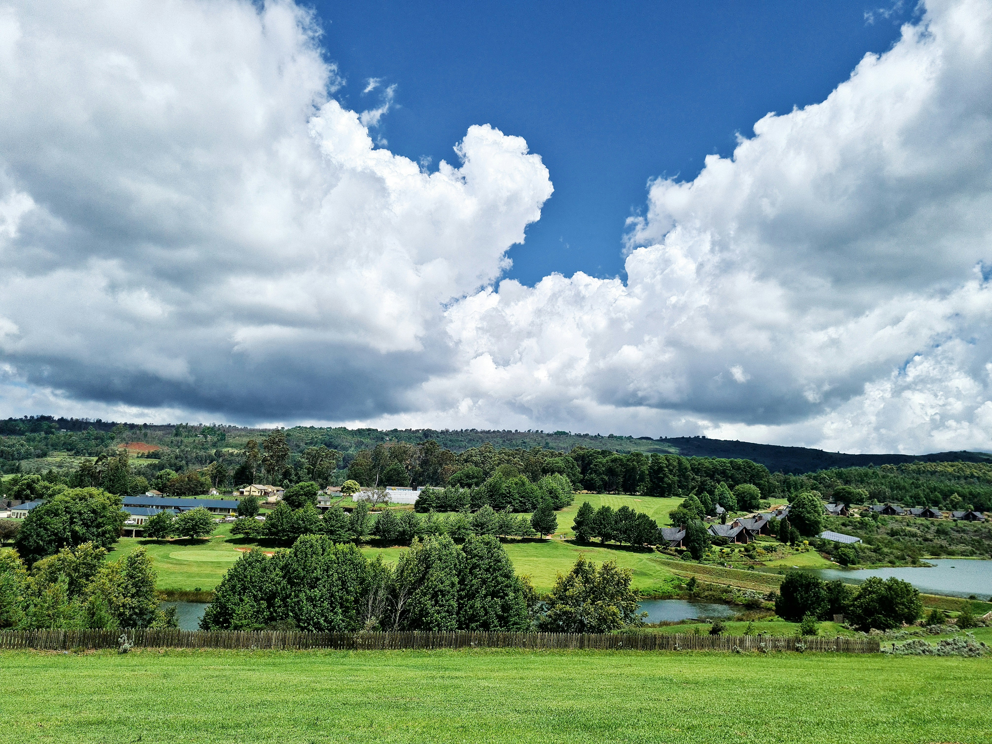 Green field under a blue sky in Nyanga, Zimbabwe.